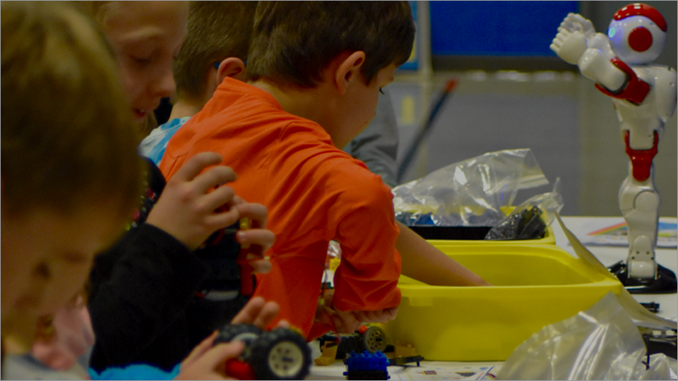 Kids collaborating on robotics kits at a RoboThink program